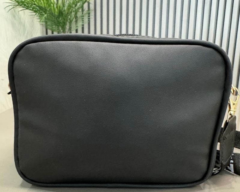 Black bag with gold zipper on a light background